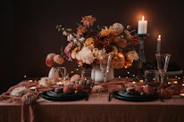 Close-up of a beautifully arranged table setting with vibrant flowers and candles.
