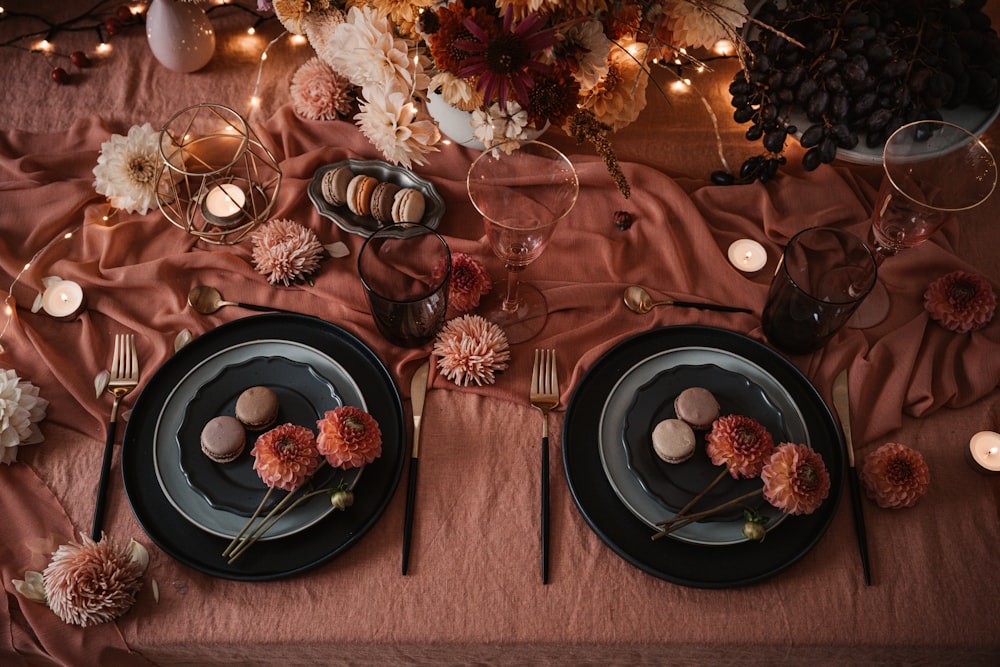 two plates with flowers and candles on a table