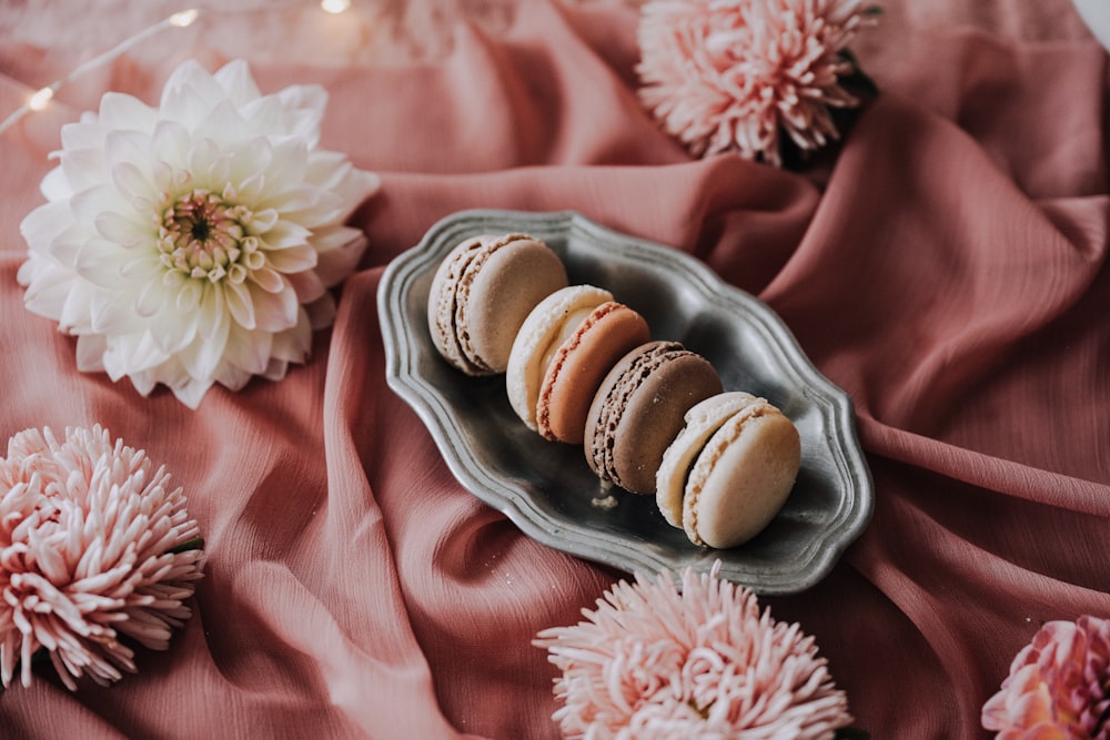 a plate of macaroons on a pink cloth
