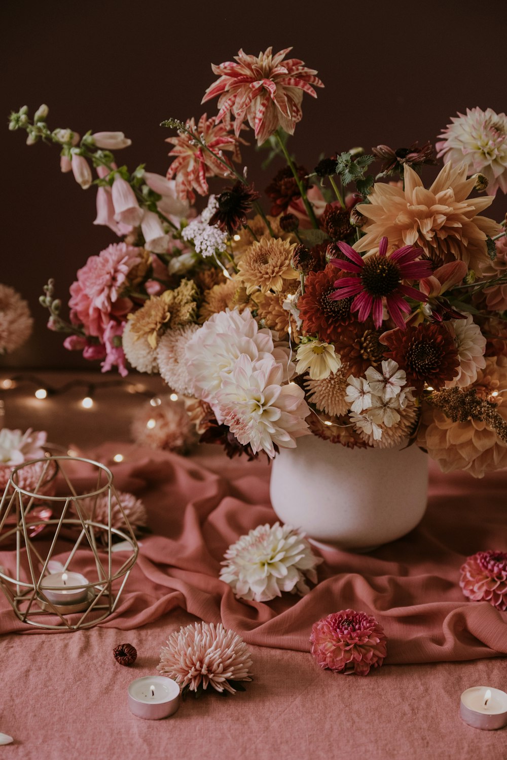 a vase filled with lots of flowers on top of a table