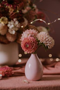A delicate pastel pink floral arrangement with hints of green leaves, styled in a bohemian Rajasthani-inspired vase.