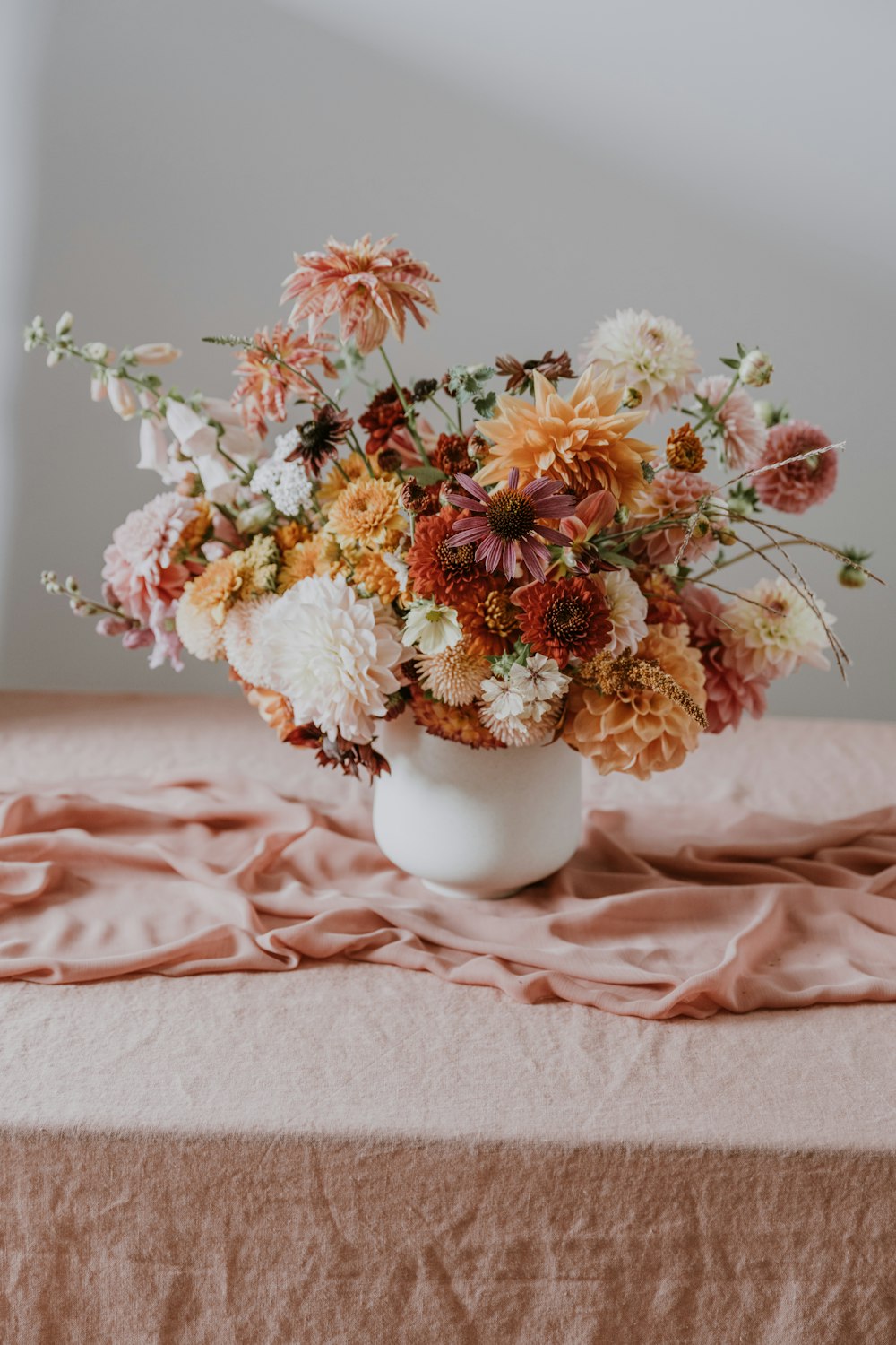 a vase filled with lots of flowers on top of a table