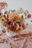 A festive celebration display with mixed seasonal flowers in warm autumn tones.