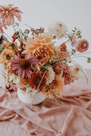 A vibrant bouquet of autumn-hued flowers arranged with delicate petals in a cozy Singaporean home setting.