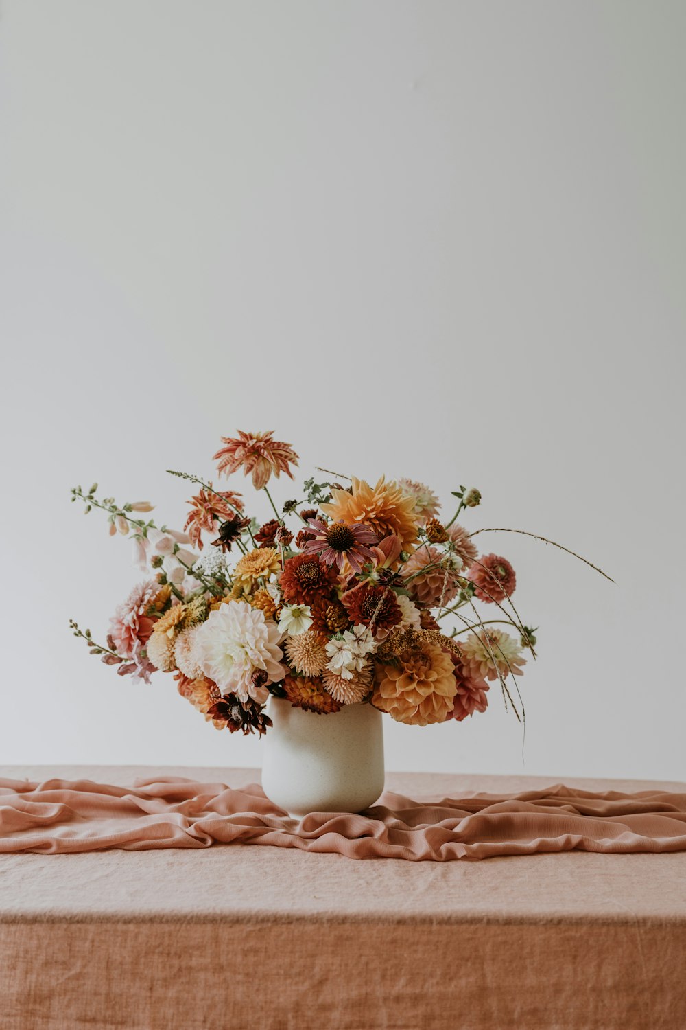 a vase filled with lots of flowers on top of a table