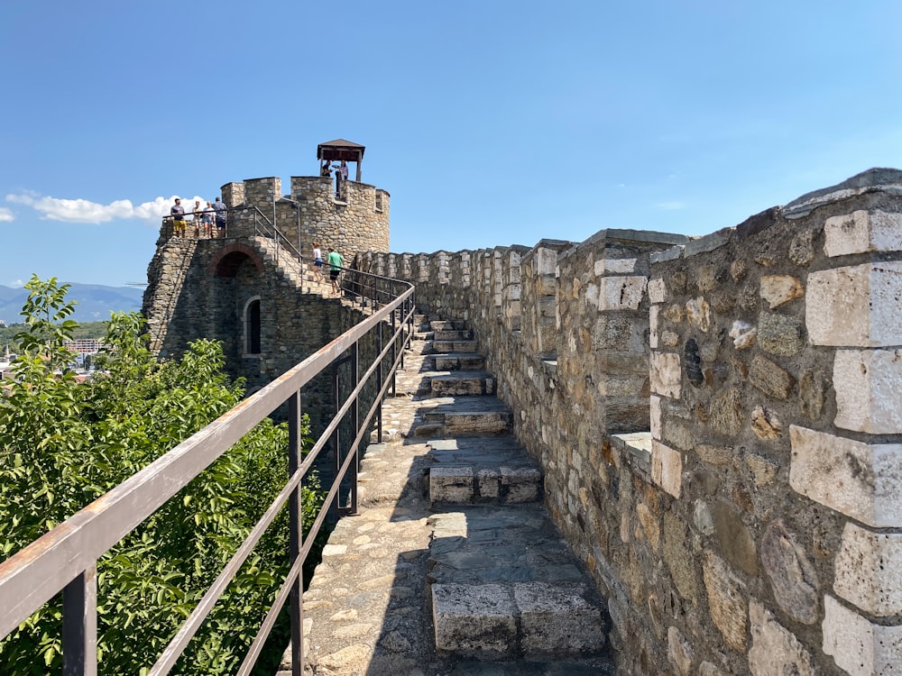 a stone wall with steps leading up to a tower