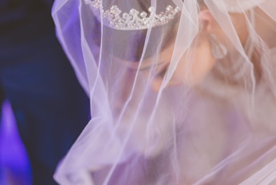 Soft-focus image of shimmering bridal hairpins scattered on lace fabric