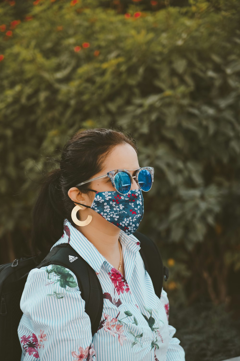 a woman wearing a face mask and sunglasses