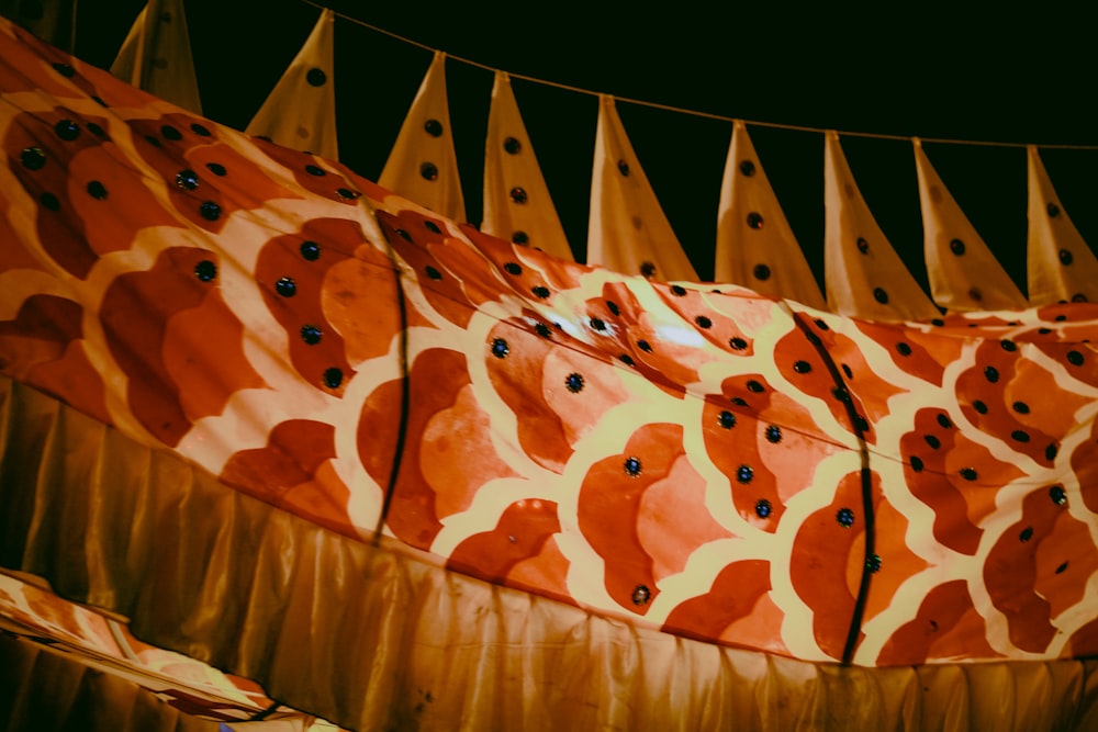 a group of orange and yellow umbrellas hanging from a line