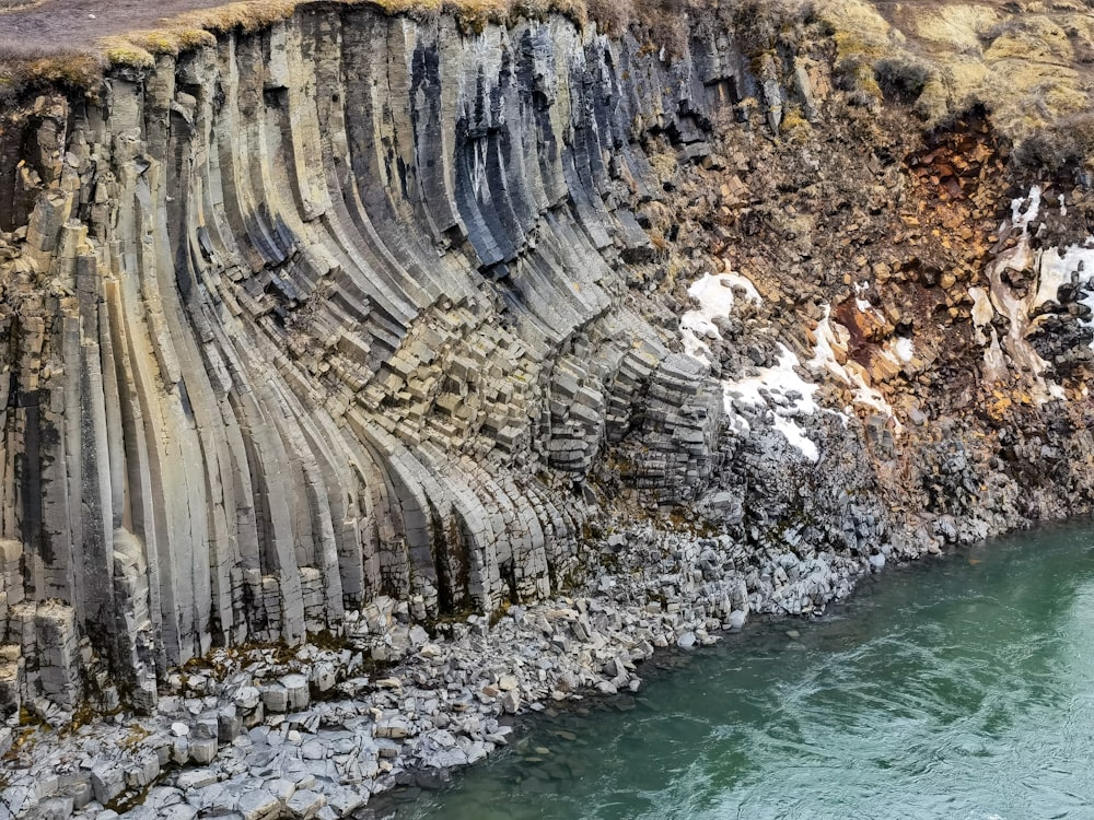 a cliff with a body of water below it