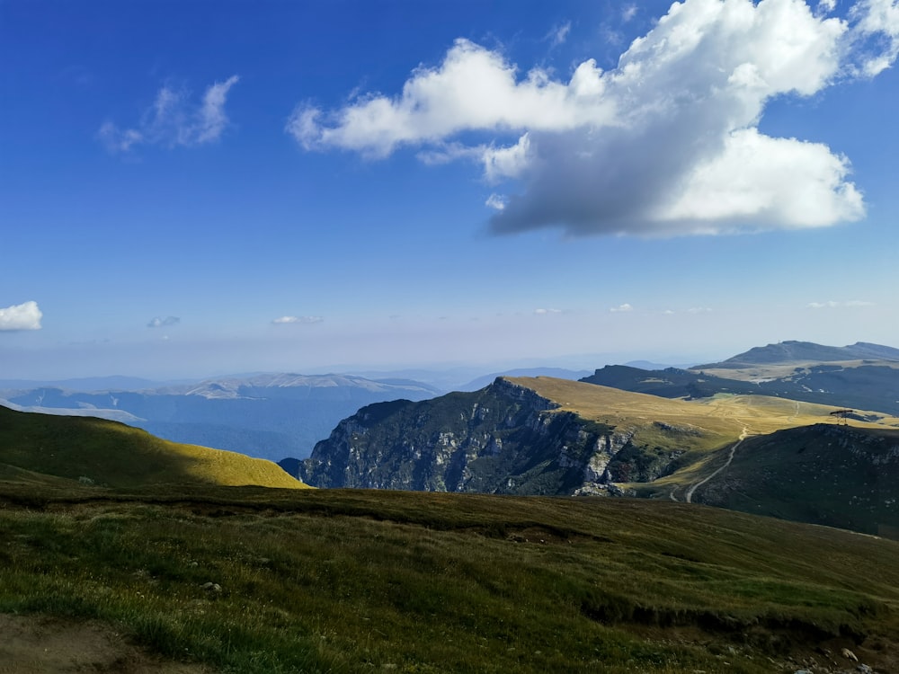 a view of a mountain range with a few clouds in the sky