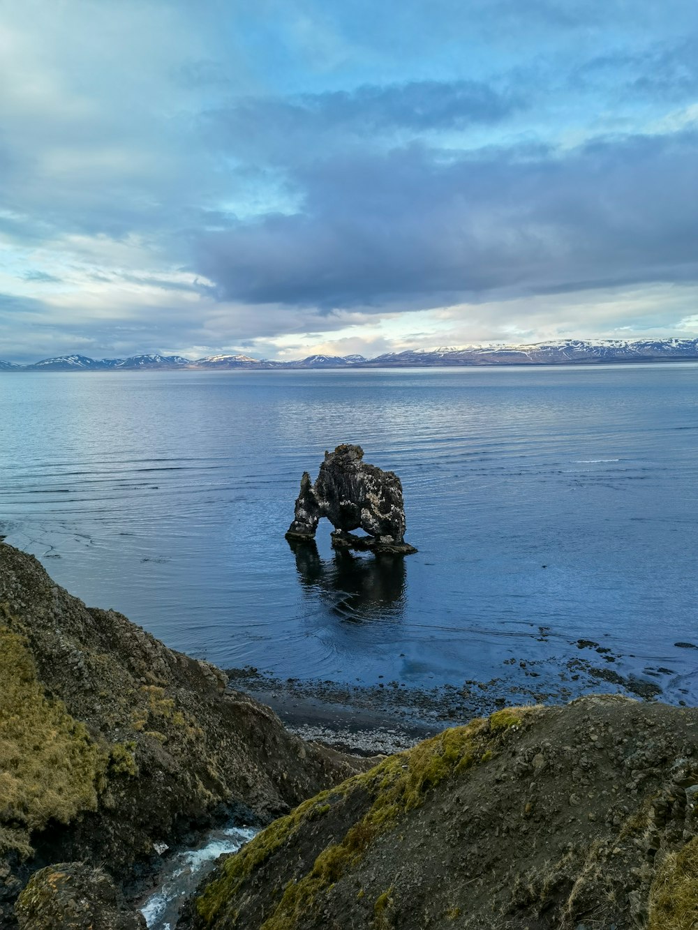 a large rock in the middle of a body of water