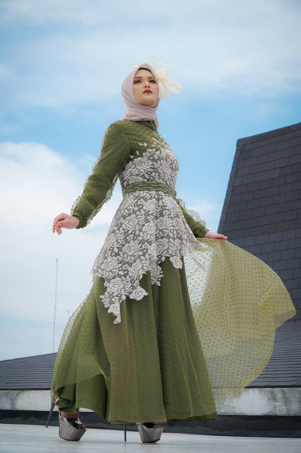 a woman in a green and white dress and hijab