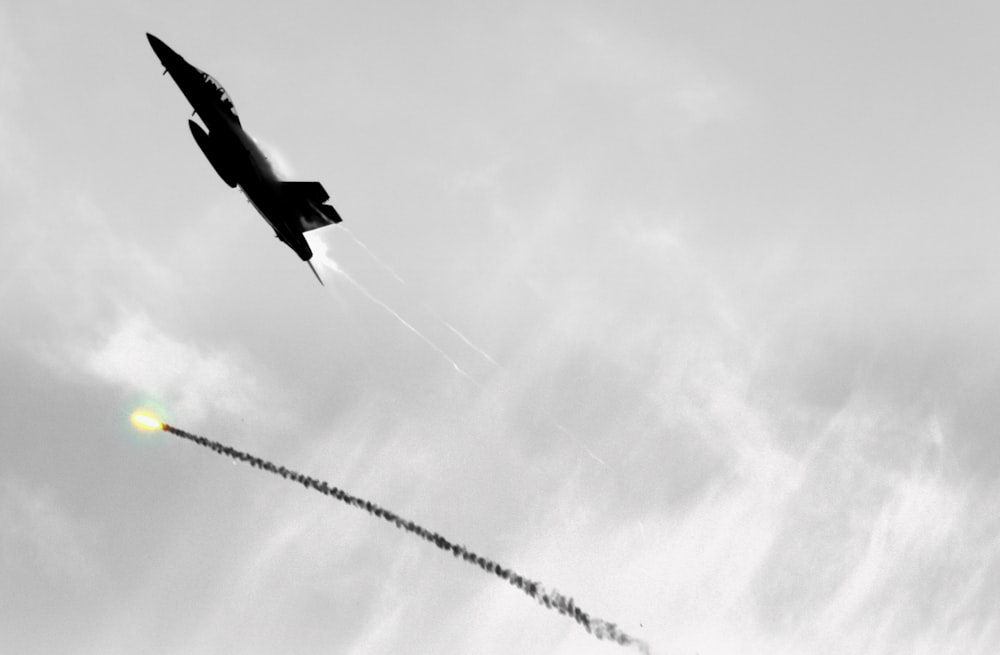 uma foto em preto e branco de um jato voando no céu