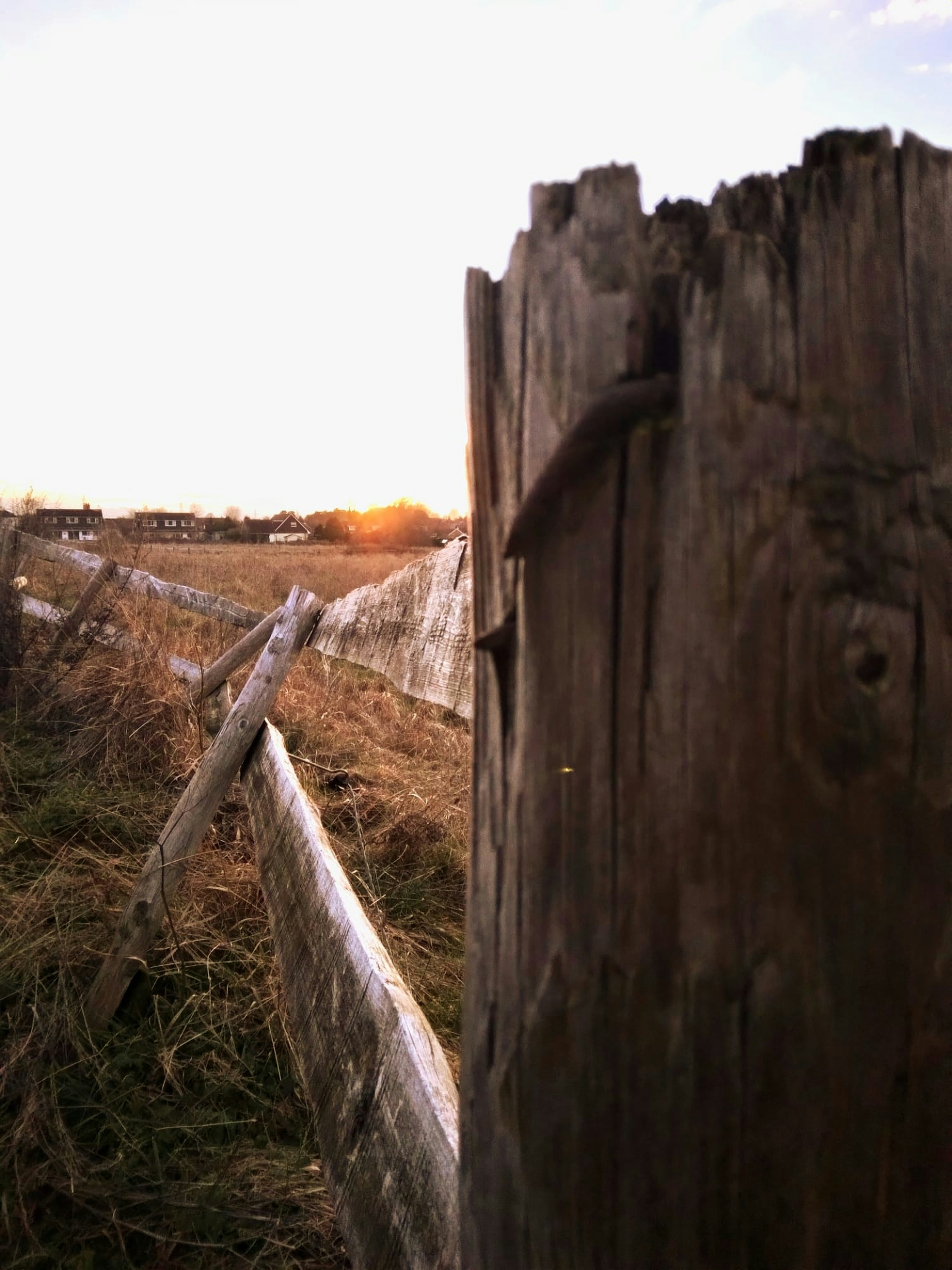 a wooden fence in the middle of a field