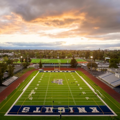 an aerial view of a football field at sunset