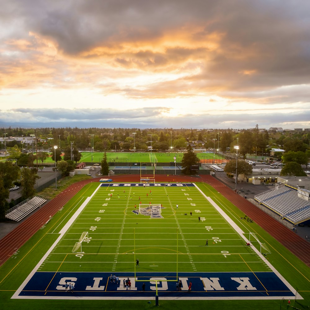 an aerial view of a football field at sunset