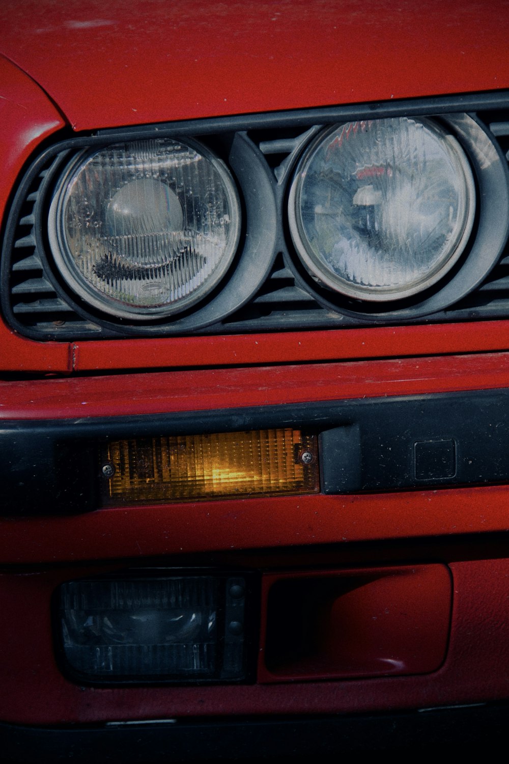 a close up of a red car's headlights