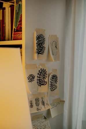 Colorful sketches and designs pinned on a wall.