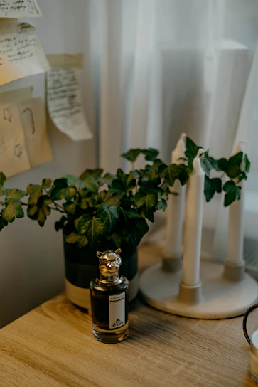 A cozy workspace with perfume bottles, dried flowers, and handwritten scent notes on a wooden table.