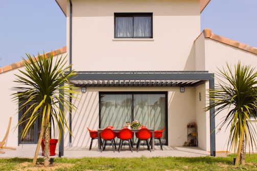 a white house with a red table and chairs