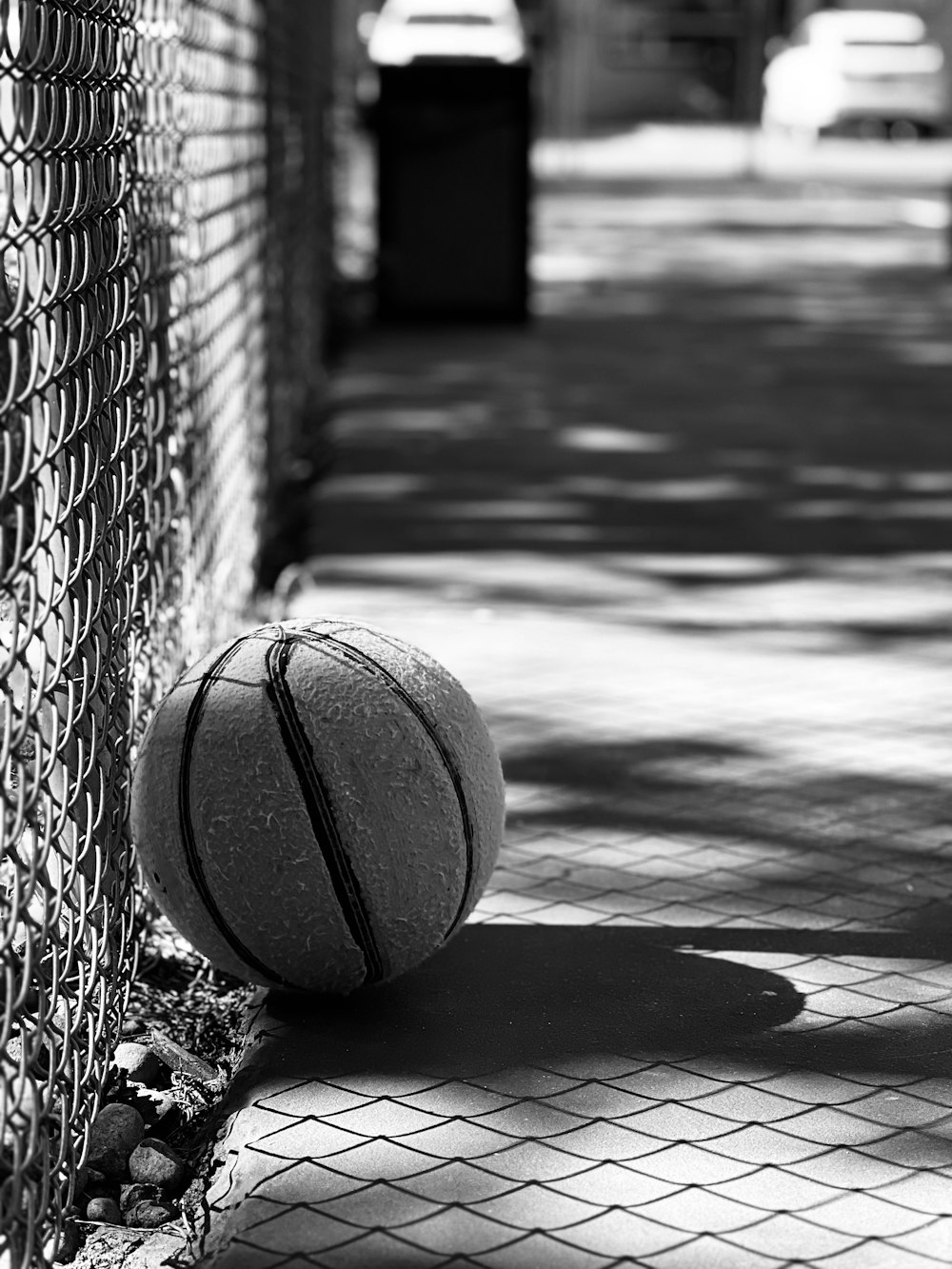 a basketball sitting on the ground next to a fence