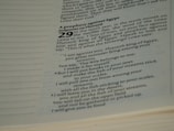 The image contains a close-up of text from a religious book, specifically a passage highlighting a prophecy against Egypt. The text is printed in a modern typeface, with bold numbers and headers. The focused portion includes a prophecy involving Pharaoh, with poetic language.