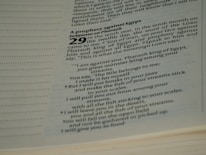 The image contains a close-up of text from a religious book, specifically a passage highlighting a prophecy against Egypt. The text is printed in a modern typeface, with bold numbers and headers. The focused portion includes a prophecy involving Pharaoh, with poetic language.