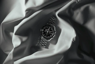 Close-up of a vintage Omega watch resting on a dark navy velvet cloth with gold accents softly glowing.