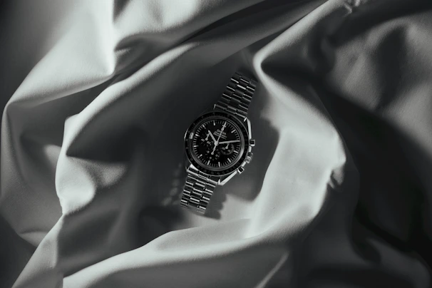 Close-up of a vintage Omega watch resting on a dark navy velvet cloth with gold accents softly glowing.