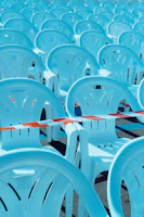 Powder-coated crowd control barriers lined up neatly at a large outdoor event under clear skies.
