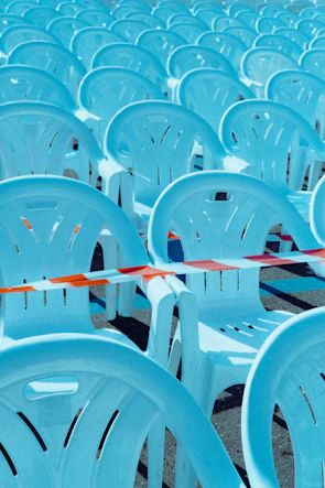 Powder-coated crowd control barriers lined up neatly at a large outdoor event under clear skies.