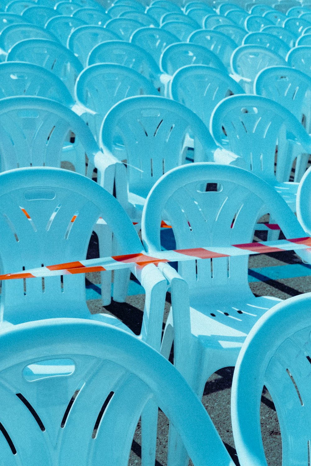 a row of white plastic chairs sitting next to each other