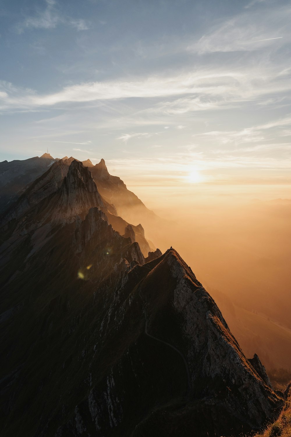 the sun is setting over a mountain range