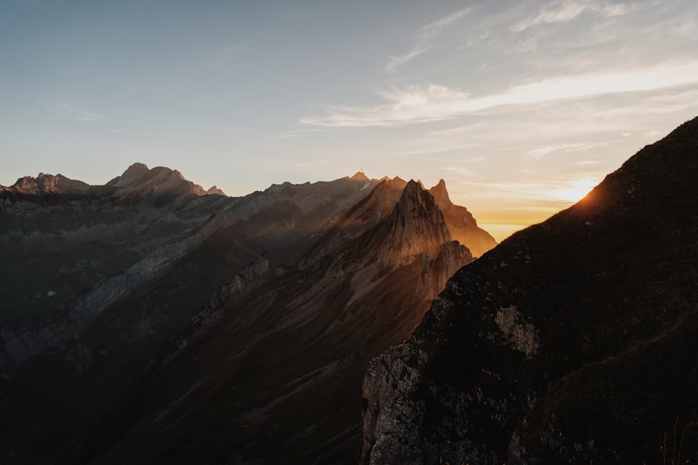 the sun is setting on a mountain range