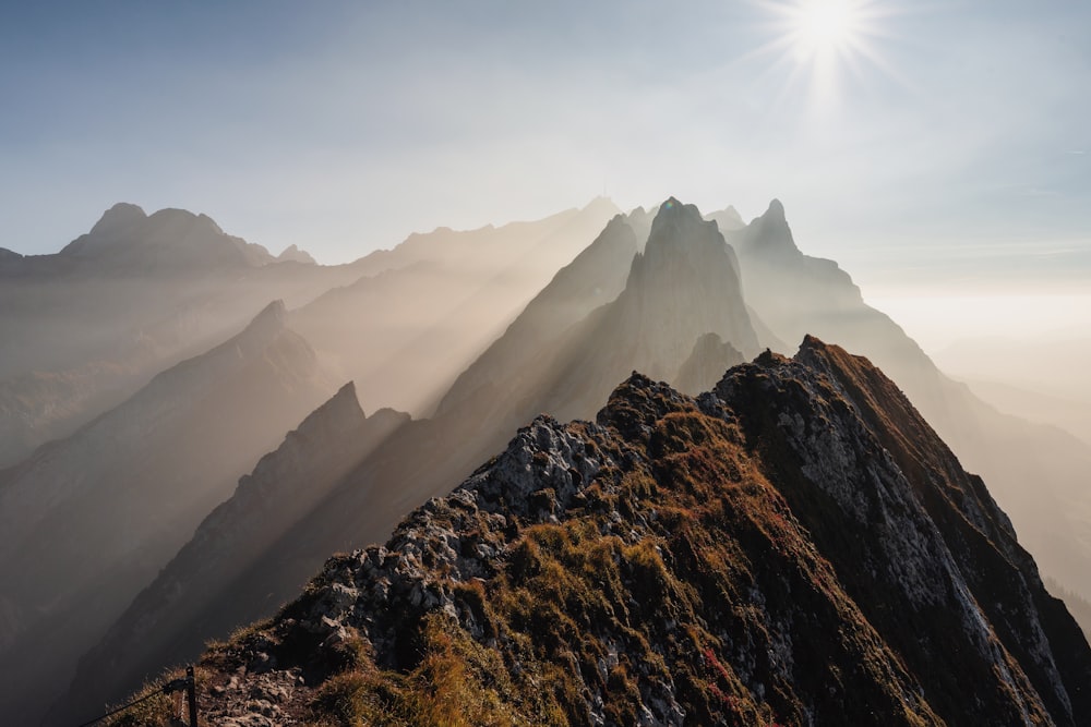 the sun shines brightly on a mountain peak