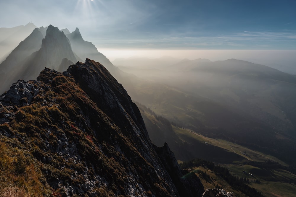 the sun shines on a mountain peak