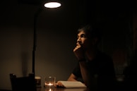 A person thoughtfully reviewing career astrology reports by candlelight.