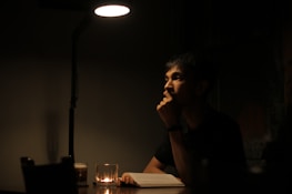 A calm, focused moment of a guide interpreting a life-purpose reading in soft ivory light.