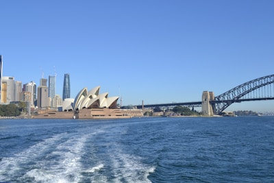 A panoramic view of a famous opera house beside a sparkling harbor.