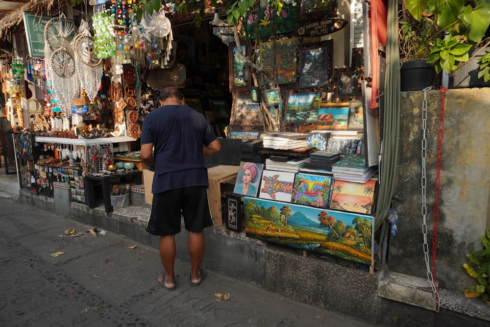 a man standing in front of a store selling items