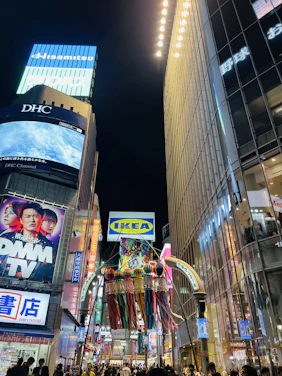 A vibrant city street scene with diverse people looking at bright, eye-catching billboards.