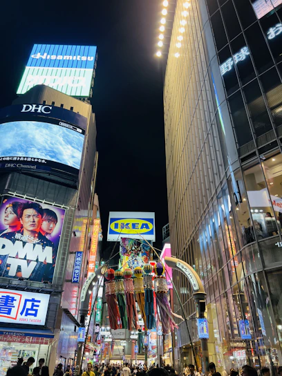 A vibrant city street scene with diverse people looking at bright, eye-catching billboards.