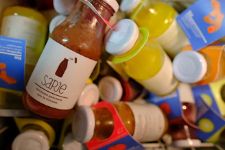 A selection of bottled natural juices and smoothies with vibrant labels on a wooden table.