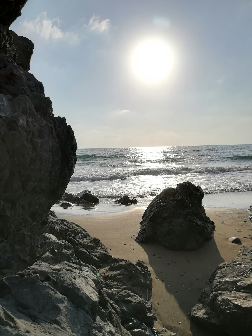 Die Sonne scheint über das Meer und die Felsen