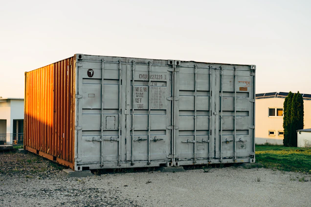 A glowing, cyber-industrial styled shipping container with subtle orange highlights against a black background.