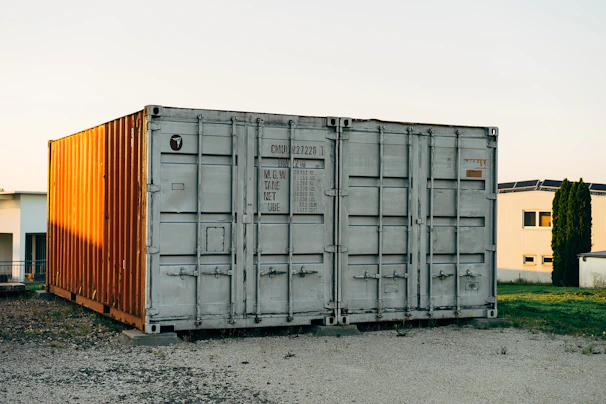 A spacious 12-meter office container featuring insulation panels and electrical fittings, placed in a green outdoor area.