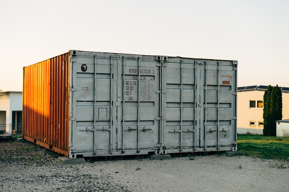 a couple of shipping containers sitting on top of a dirt field