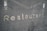 Metallic letters spelling 'Restaurant' are embedded against a textured, dark gray surface. The surface features horizontal grooves giving it a modern, industrial look.