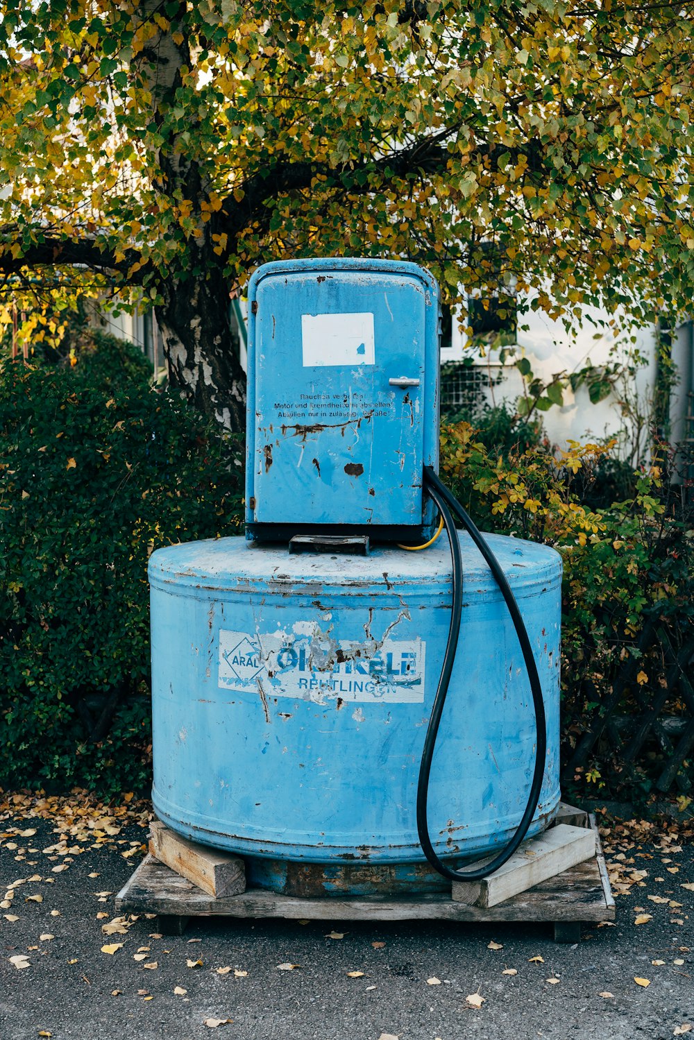 a blue gas tank sitting on top of a wooden pallet